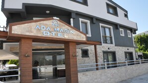 L’entrée de l’hôtel ADA MARIN, avec sa façade en pierre et son design moderne.