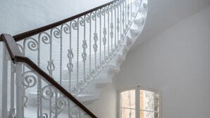 A white marble staircase with ornate metal railings and a wooden handrail. - Valletta Kampnar City Living (Valletta)