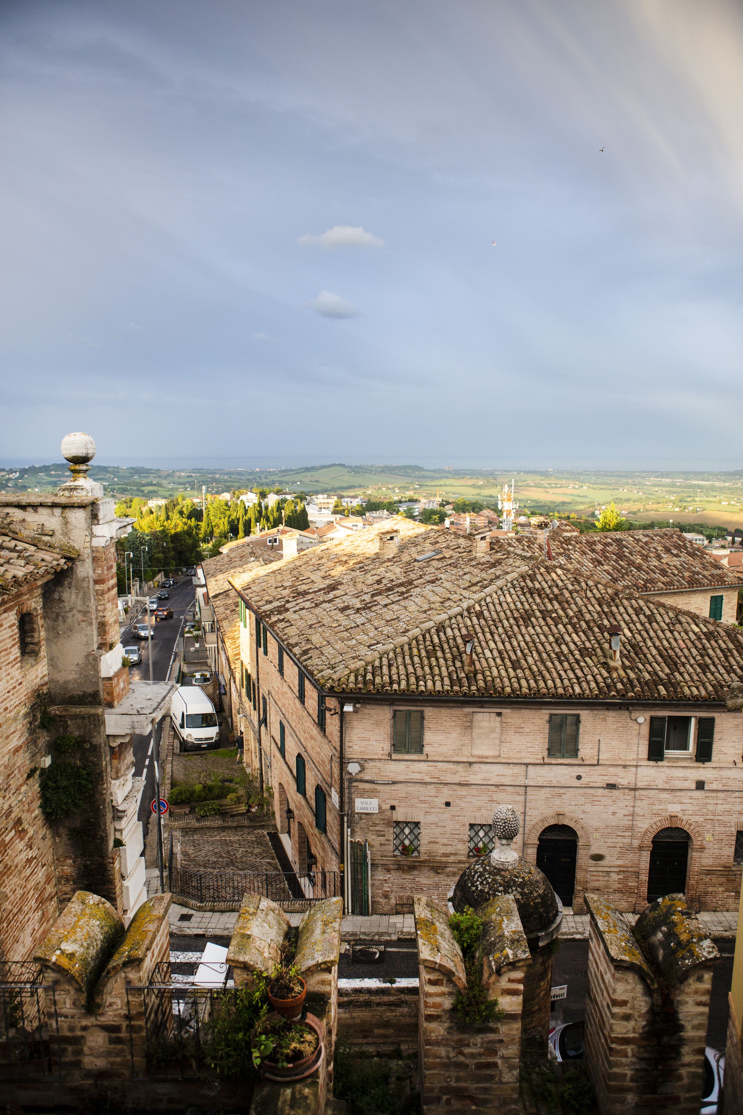 A historic building with a tiled roof, narrow streets, and a view of the countryside.
