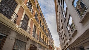 A multi-story building with a brick facade, multiple balconies with wrought iron railings, and a storefront with a sign that reads "Restaurante". - Soho Boutique Congreso (Madrid)