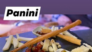 Una tabla de quesos con diferentes tipos de queso, galletas y aceitunas.
