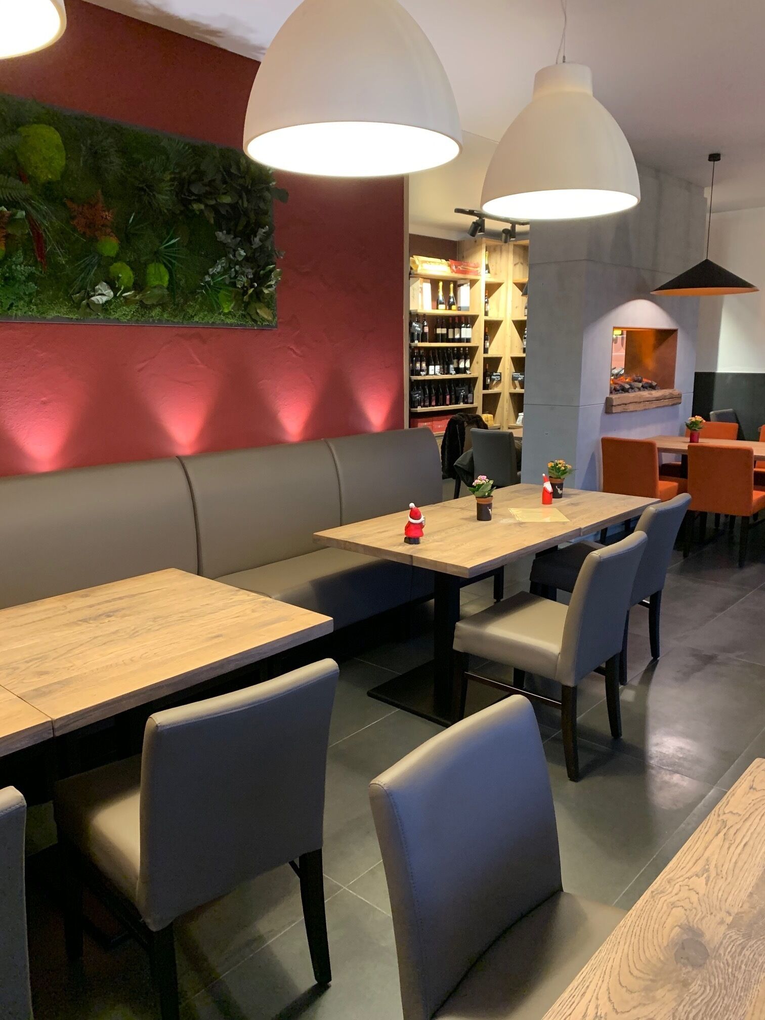 A restaurant interior with wooden tables and grey upholstered benches.