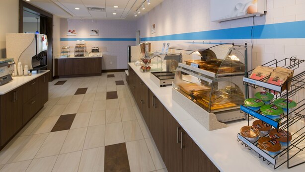 A modern breakfast area with a self-serve station, a microwave, and a display of food options. - Holiday Inn Express & Suites Millersburg by IHG (Millersburg)