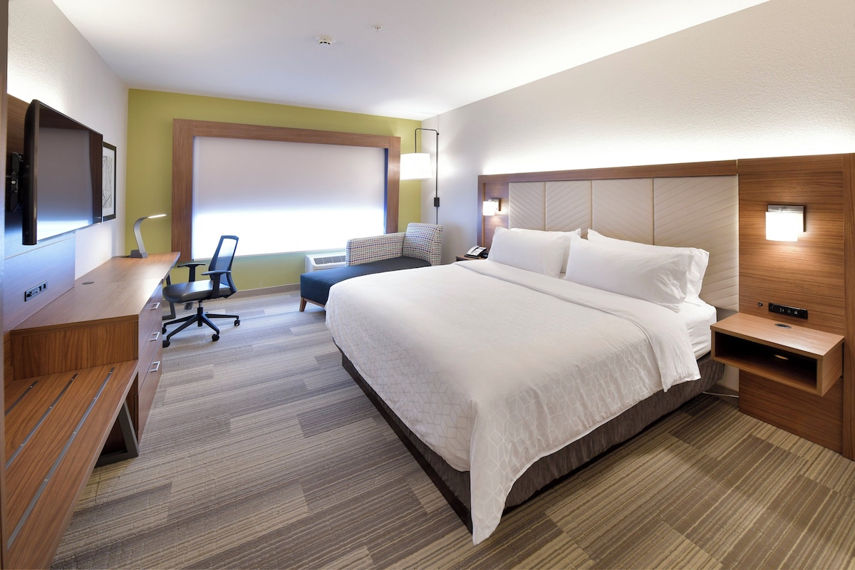 Une chambre d’hôtel équipée d’un lit, d’un bureau, d’une chaise et d’un téléviseur.