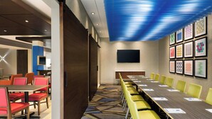 A conference room with a long table, yellow chairs, and a patterned carpet. - Holiday Inn Express & Suites Millersburg by IHG (Millersburg)