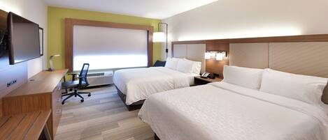 A hotel room with two beds, a desk with a chair, a flat-screen TV, and a window with blinds.