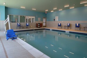 A swimming pool with blue chairs and a lifeguard stand. - Holiday Inn Express & Suites Tulsa Downtown by IHG (Tulsa)