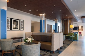 A lobby with seating areas, a reception desk, and framed artwork on the walls. - Holiday Inn Express & Suites Tulsa Downtown by IHG (Tulsa)