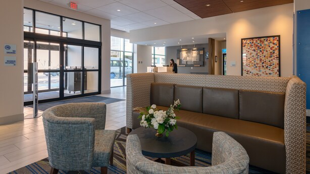 A lobby with a seating area, a reception desk, and a large glass door entrance.
