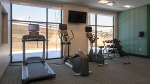 A gym with treadmills, elliptical machines, and weight equipment.