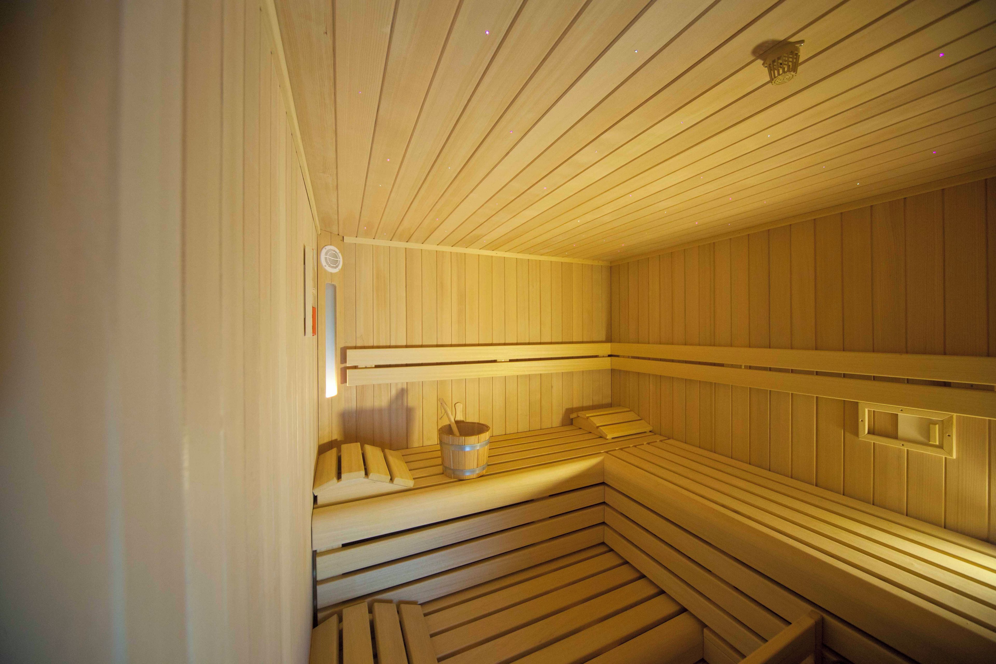 Eine Sauna mit Holzbänken und einem Eimer.