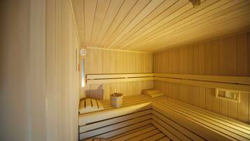 Uma sauna com bancos de madeira e um balde.