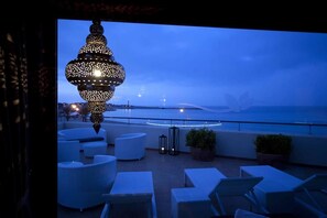 A rooftop terrace with seating and a decorative hanging light fixture. - Miraspiaggia (San Vito Lo Capo)