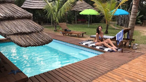 A wooden deck with a pool, lounge chairs, and umbrellas. - Visgraat Luxury Self Catering Unit (uMhlabuyalingana)