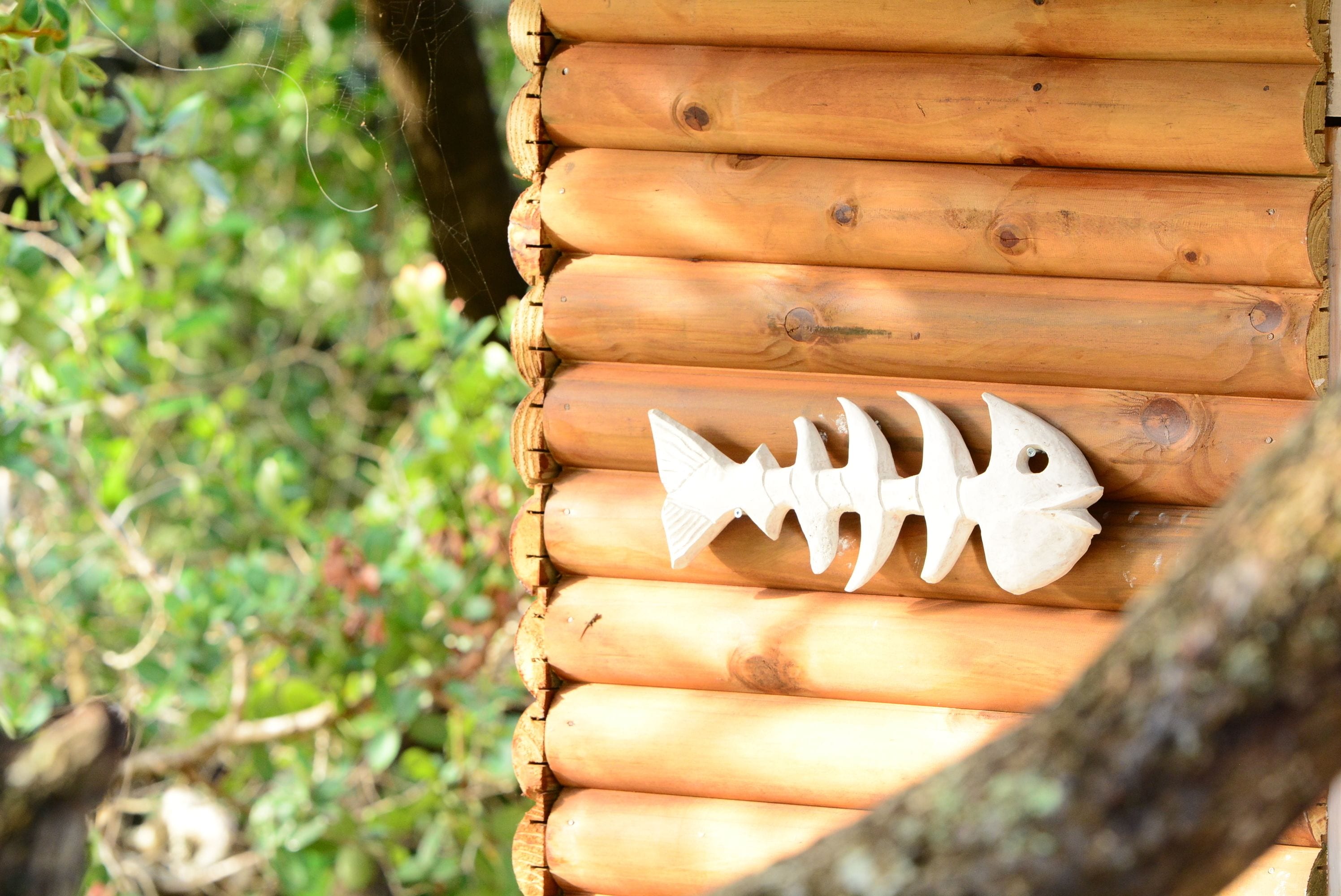 A wooden log cabin with a fish-shaped decoration on the wall.