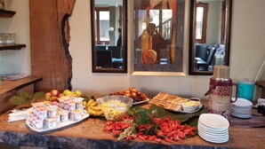 A buffet table with various food items and a decorative mirror. - Visgraat Luxury Self Catering Unit (uMhlabuyalingana)