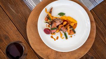 A white plate with food on a wooden table.