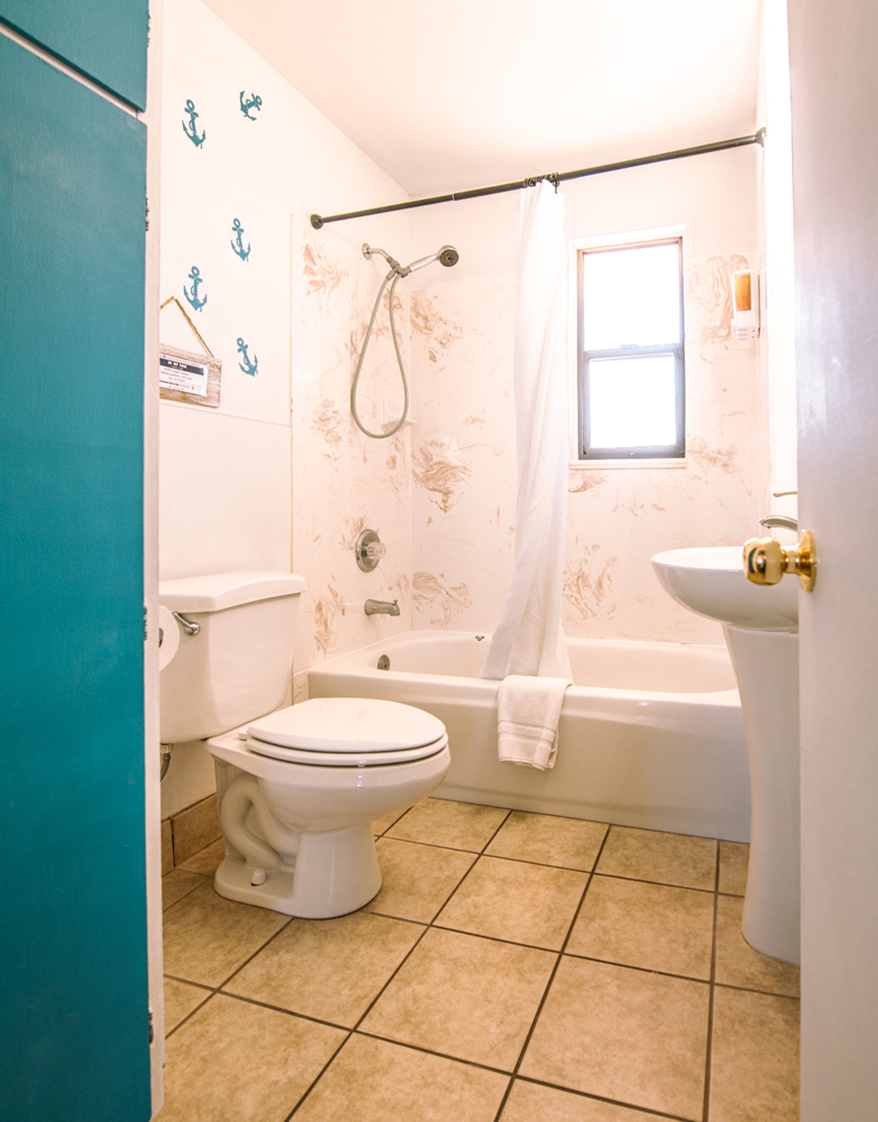 Une salle de bain comprenant des toilettes, une baignoire et un lavabo.