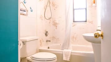 Une salle de bain comprenant des toilettes, une baignoire et un lavabo.