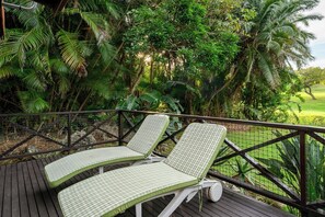 A deck with two lounge chairs and a view of a lush garden. - San Lameer Villa Rentals  2707 (Southbroom)