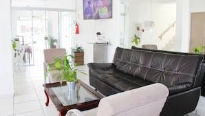 Una sala de estar moderna con un sofá de cuero, una mesa de centro de vidrio y un televisor montado en la pared.