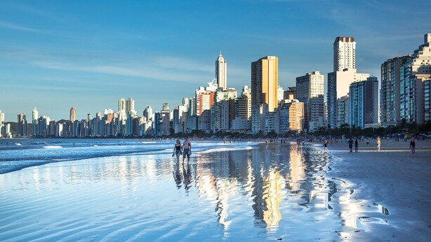 Una playa con un horizonte urbano al fondo.