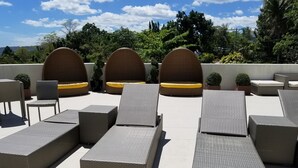 A rooftop lounge area with wicker furniture and a view of the surrounding greenery. - 1209 Two Residences Marco Polo Cebu (Cebu City)