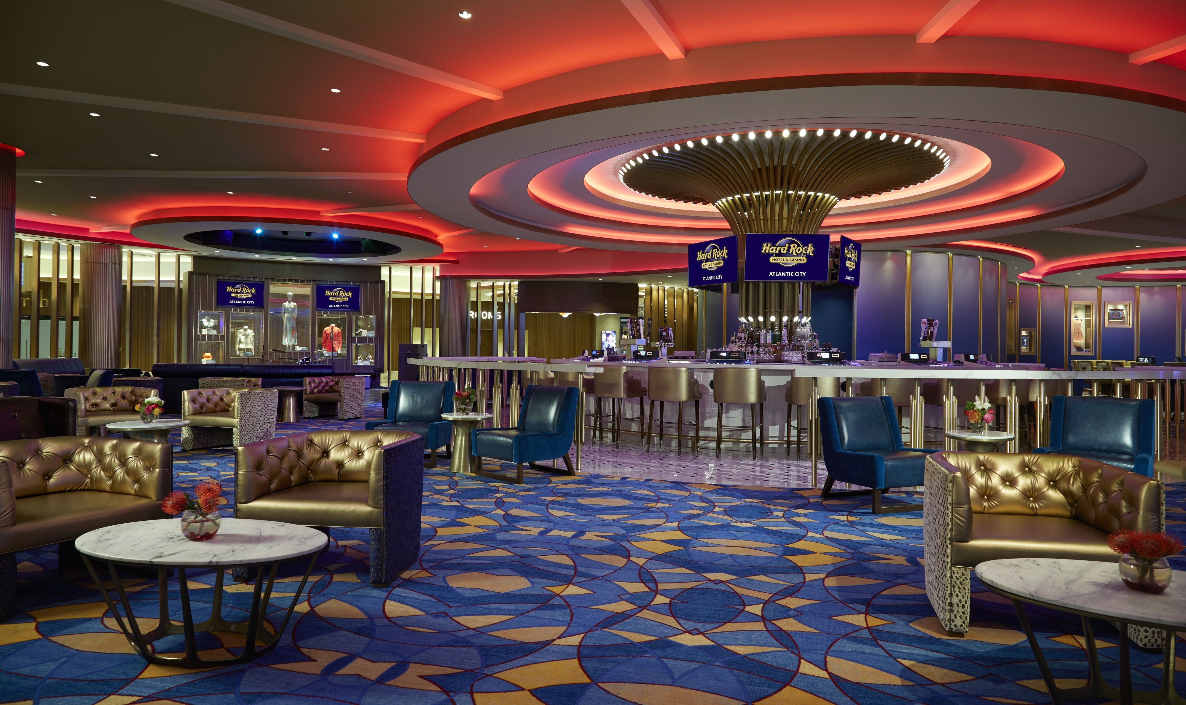 A hotel lobby with a bar area, seating arrangements, and a patterned carpet.