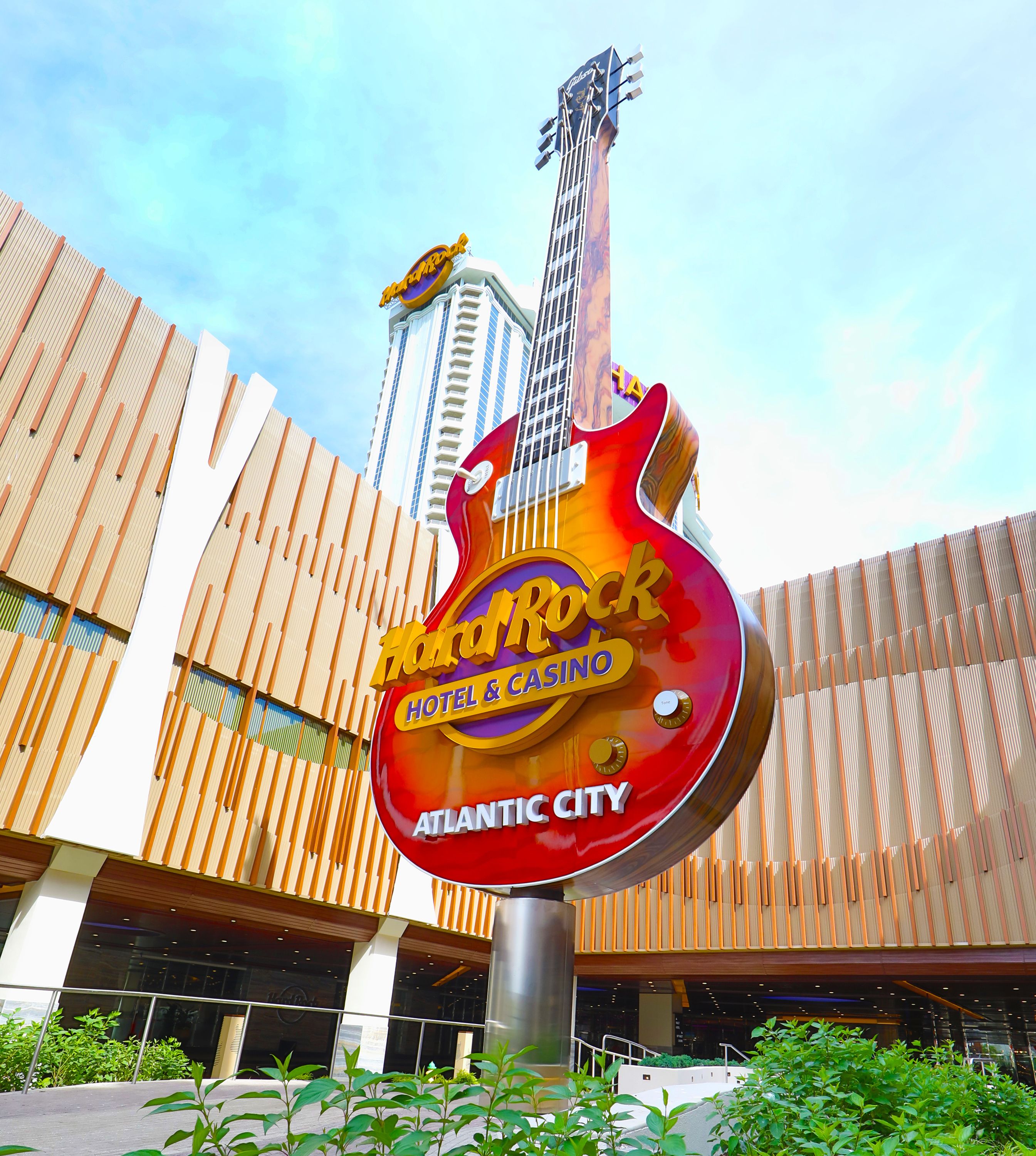 Une enseigne d’un hôtel-casino Hard Rock, avec un motif de guitare, placée sur la façade d’un bâtiment moderne.