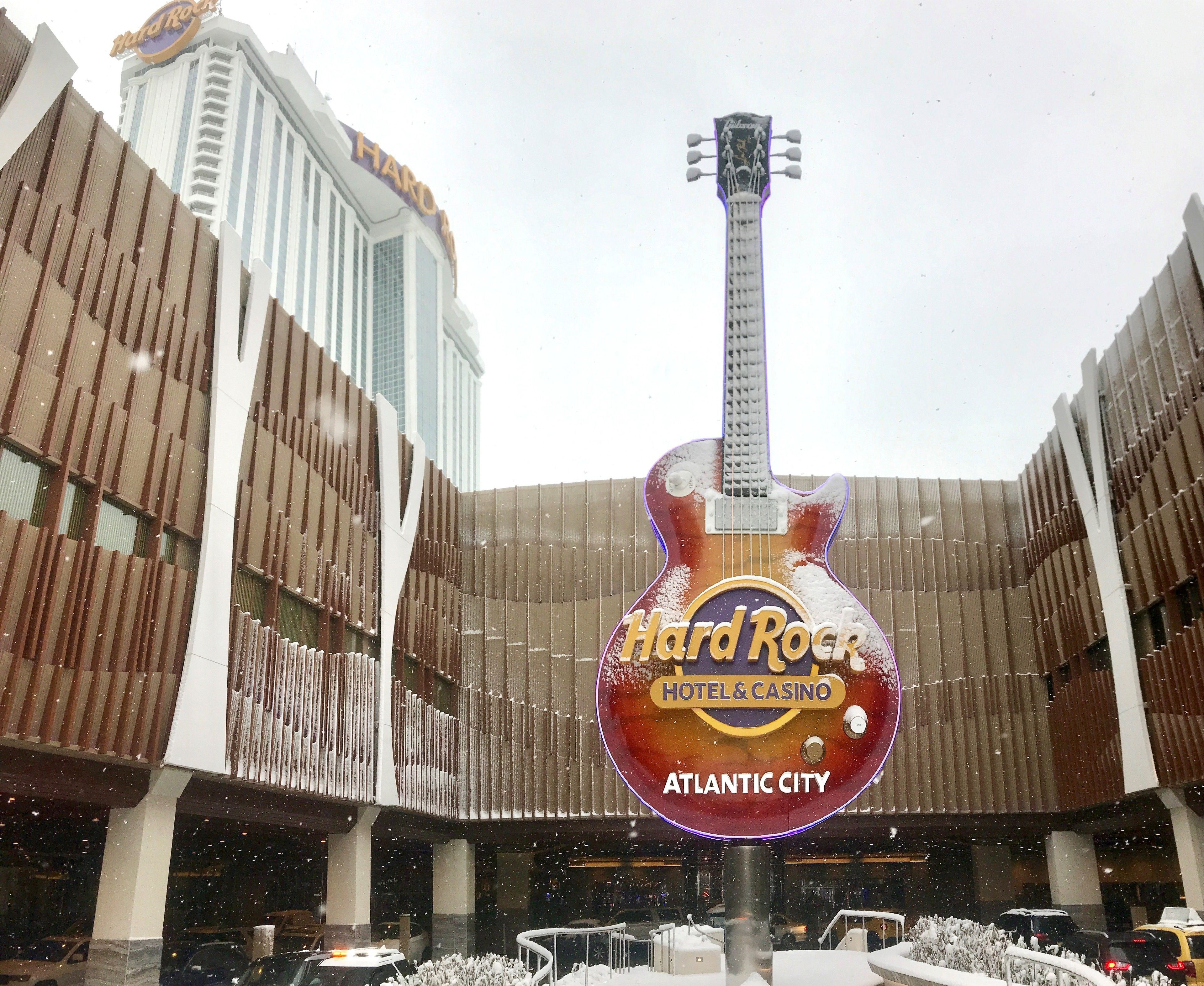 A Hard Rock Hotel & Casino sign with a guitar design, surrounded by snow.