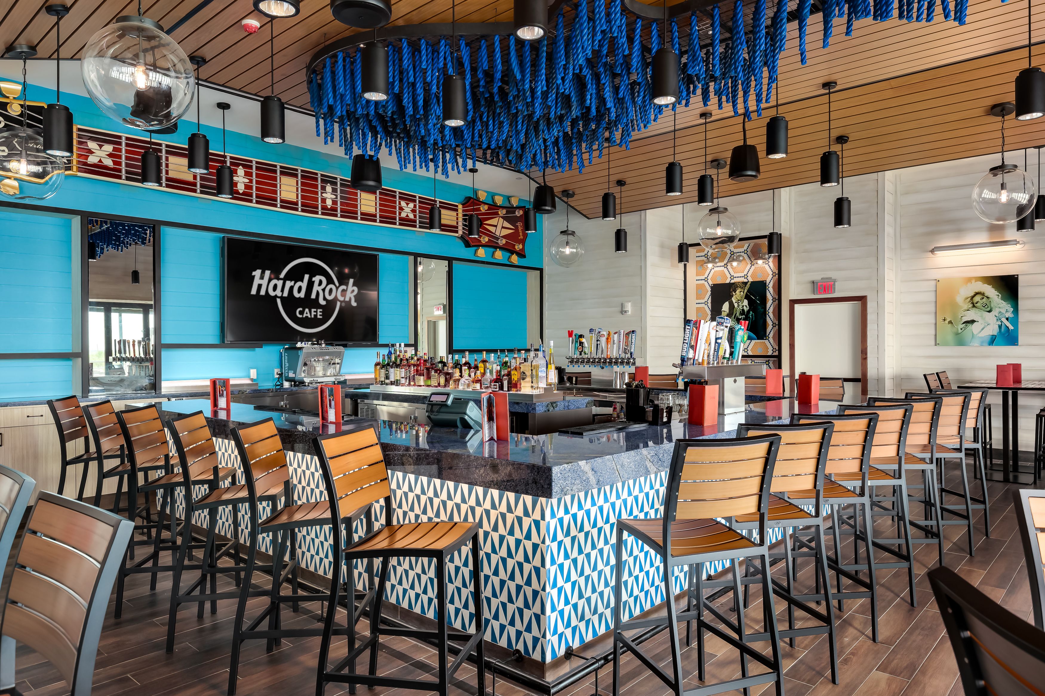 A Hard Rock Cafe with a bar area, multiple seating arrangements, and a distinctive ceiling design.