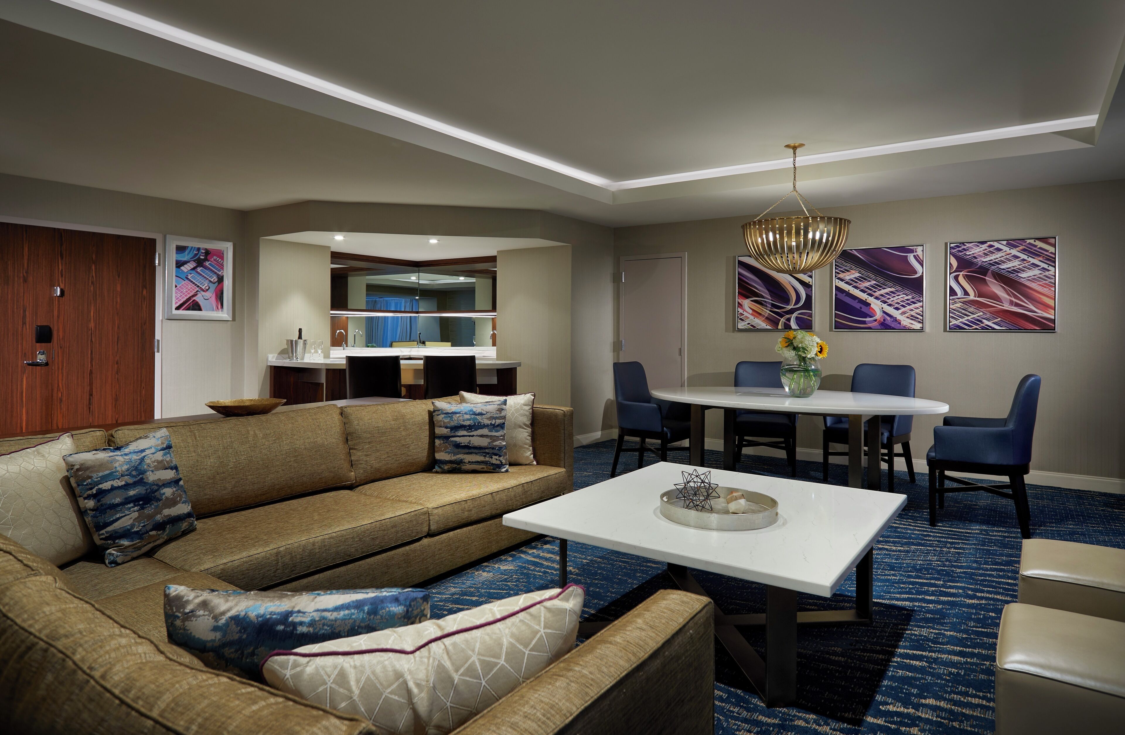 A modern living room with a sofa, coffee table, and dining area.