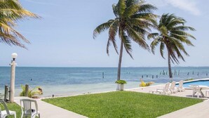 A pool area with lounge chairs and a view of the ocean. - Flamingo Beach Plus (Cancun)