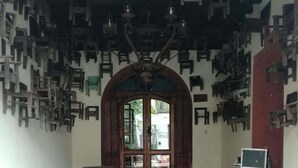 A room with a tiled floor, a wooden door with glass panels, and a ceiling with hanging light fixtures. - Posada San Sebastian (Antigua Guatemala)