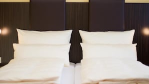 A double bed with white bedding and a dark headboard. - Pension Katharinenschule (Eisenach)