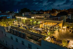 A rooftop restaurant with outdoor seating, air conditioning units, and a view of the city skyline at night. - Gran Hotel Europa Santo Domingo, Trademark by Wyndham (Santo Domingo)