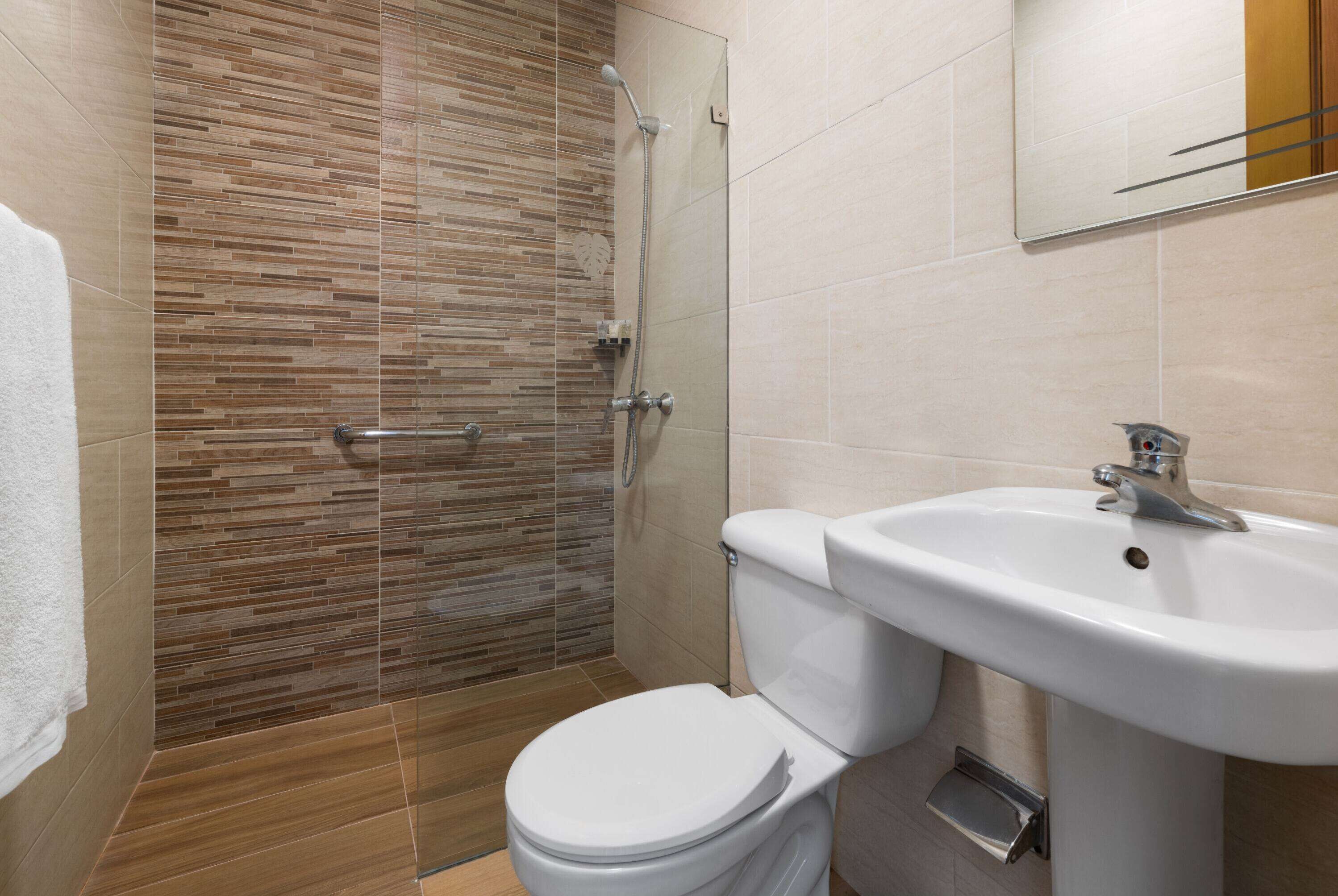 Ein Badezimmer mit Dusche, Toilette und Waschbecken.