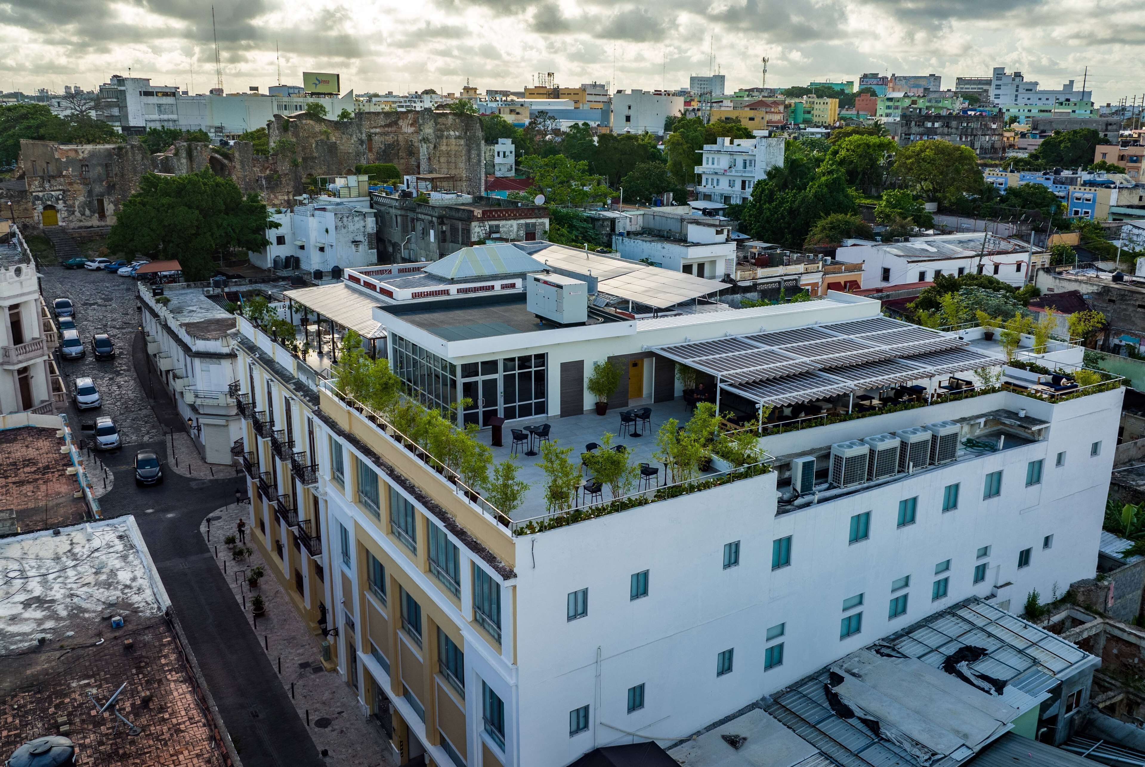 Ein mehrstöckiges Gebäude mit Dachterrasse, Blick auf die Straße und umliegende Stadtgebäude.