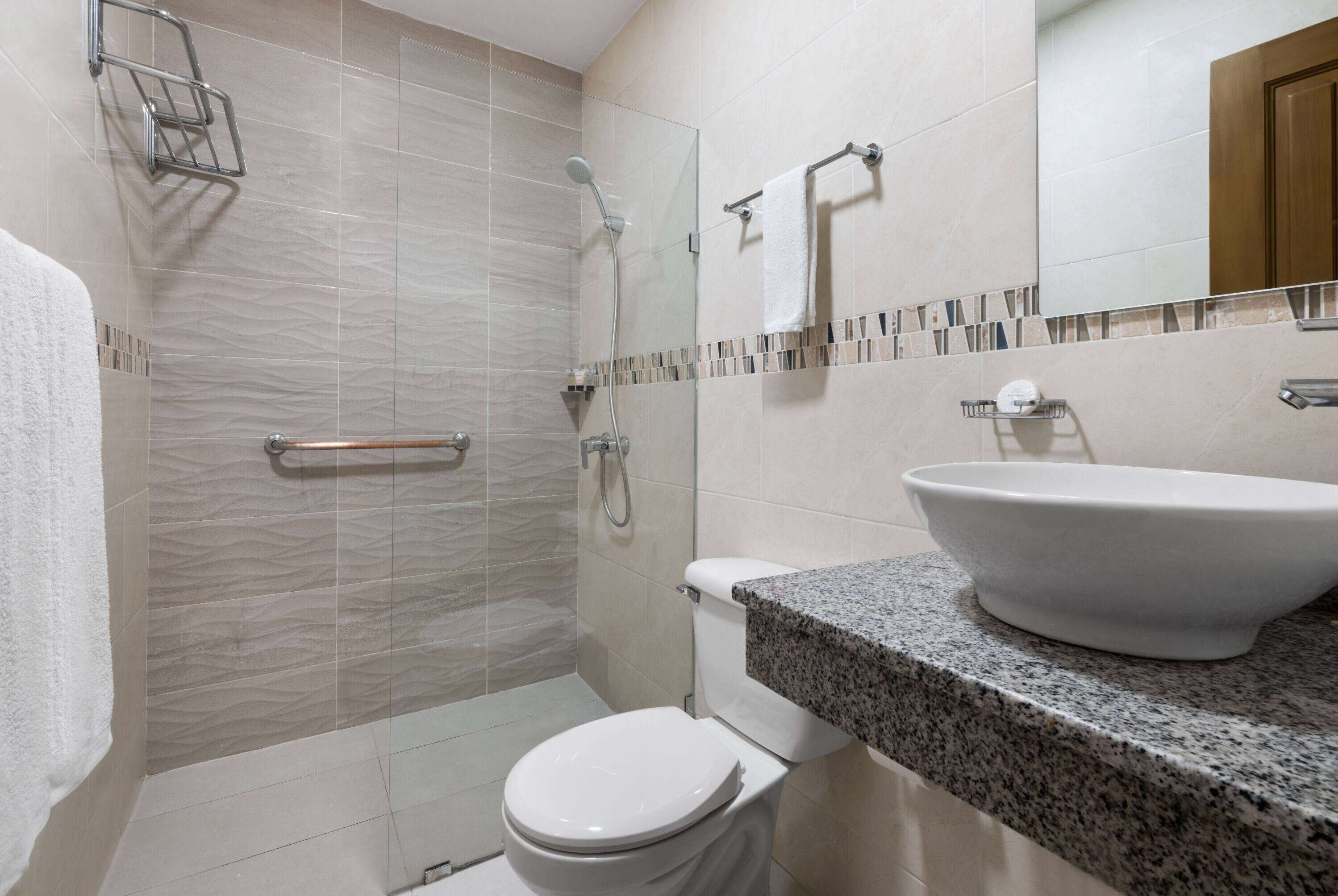 Un baño moderno con ducha, inodoro y lavamanos.