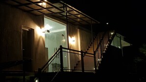 Un edificio moderno con fachada de vidrio, una escalera y barandilla de metal.