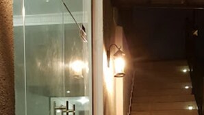 Una escalera conduce a un piso superior, con un acceso por una puerta de vidrio a la izquierda.