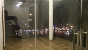 Una habitación con un amplio ventanal que da a una vista nocturna de la ciudad.