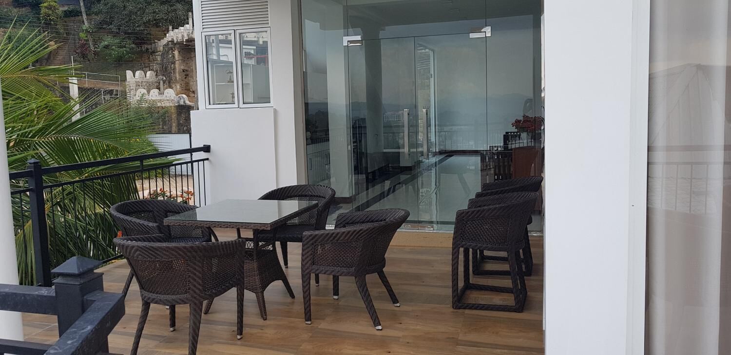 A balcony with wicker furniture, a glass door, and a view of a historic building.