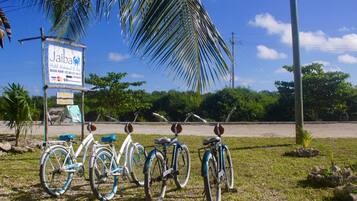 Señal de Jaiba Hotel, con una bicicleta estacionada al frente y una palmera.