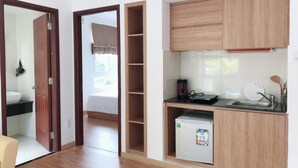 Una cucina compatta con mobili in legno, un frigorifero integrato e un lavandino piccolo.