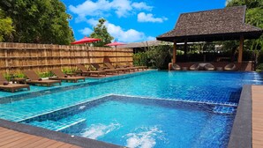 Uma piscina retangular com um deck de madeira ao redor.