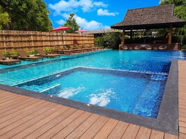 A rectangular swimming pool with a wooden deck surrounding it.