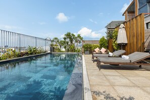 A rooftop swimming pool with lounge chairs and a view of the city. - Moon Hotel and Apartment Da Nang (Da Nang)