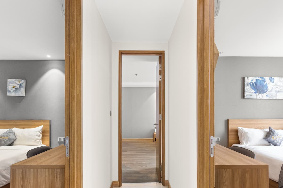 Ein Hotelzimmer mit zwei Betten, Holz-Kopfteilen und einem kleinen Schreibtisch.