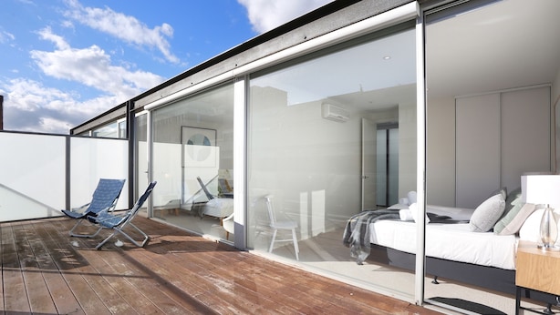 A modern room with a bed, a bedside table, and a glass wall. - StayCentral - Collingwood Penthouse (Collingwood)